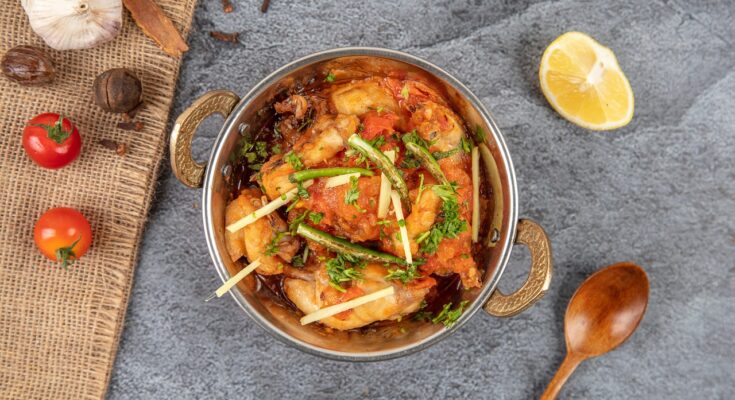 Hot and spicy chicken karahi served in a traditional wok with naan – Lahore street food.