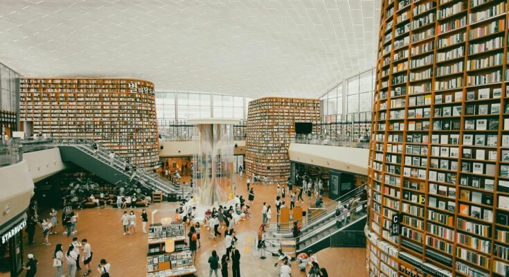 Quiet bookshop in Lahore with people reading under warm lights and bookshelves in the background
