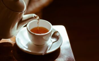 A traditional cup of chai on a wooden table at a vintage tea house in Lahore with soft ambient lighting.