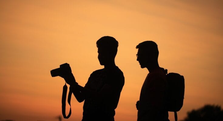 Young influencer recording a TikTok reel in front of a street art wall in Lahore.