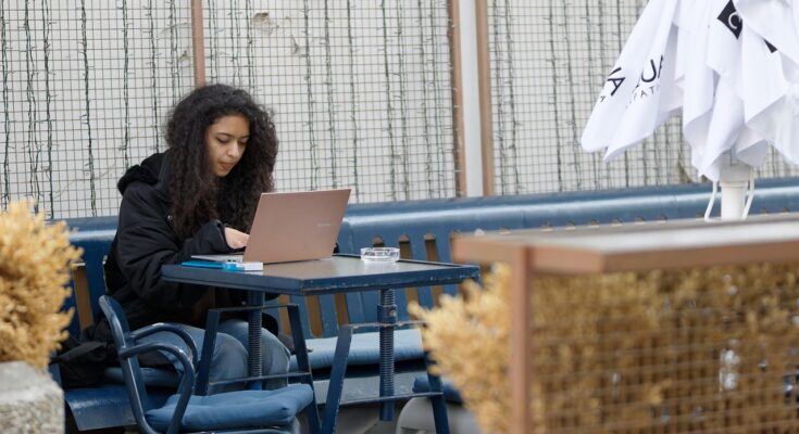 Students studying on laptops in a Lahore café with fast Wi-Fi.